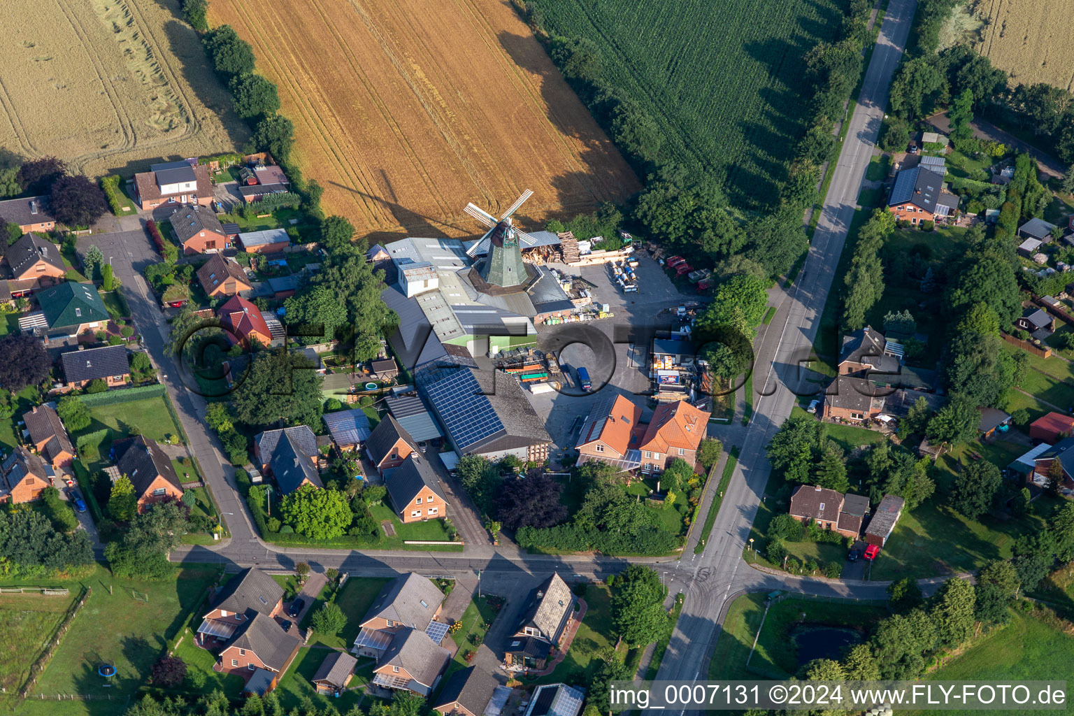 Historische Windmühle am Gehöft eines Bauernhofes von Hass Landhandel am Rand von bestellten Feldern in Süderhastedt im Bundesland Schleswig-Holstein, Deutschland