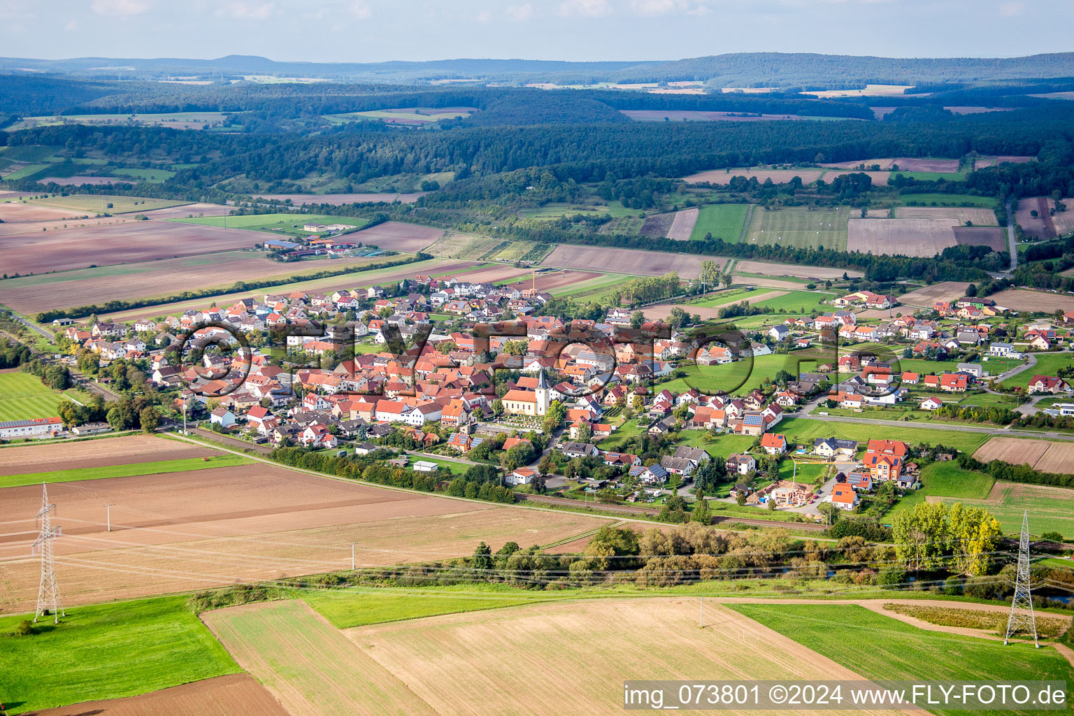 Dorf - Ansicht am Rande von landwirtschaftlichen Feldern und Nutzflächen in Staffelbach im Bundesland Bayern, Deutschland