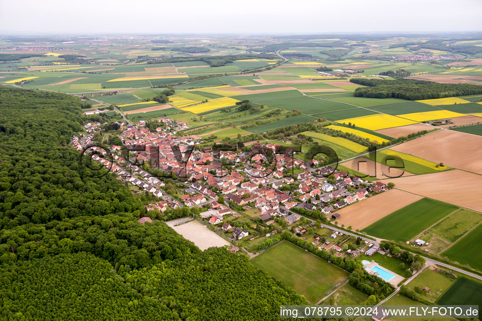 Dorf - Ansicht am Rande von landwirtschaftlichen Feldern und Nutzflächen in Schraudenbach im Bundesland Bayern, Deutschland