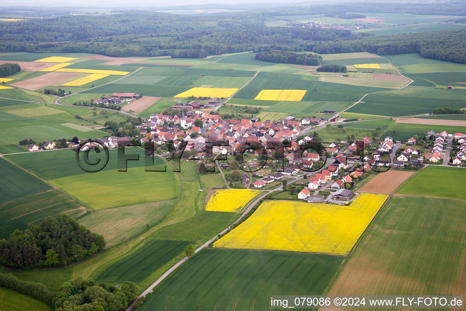 Dorf - Ansicht am Rande von landwirtschaftlichen Feldern und Nutzflächen in Ebertshausen im Bundesland Bayern, Deutschland