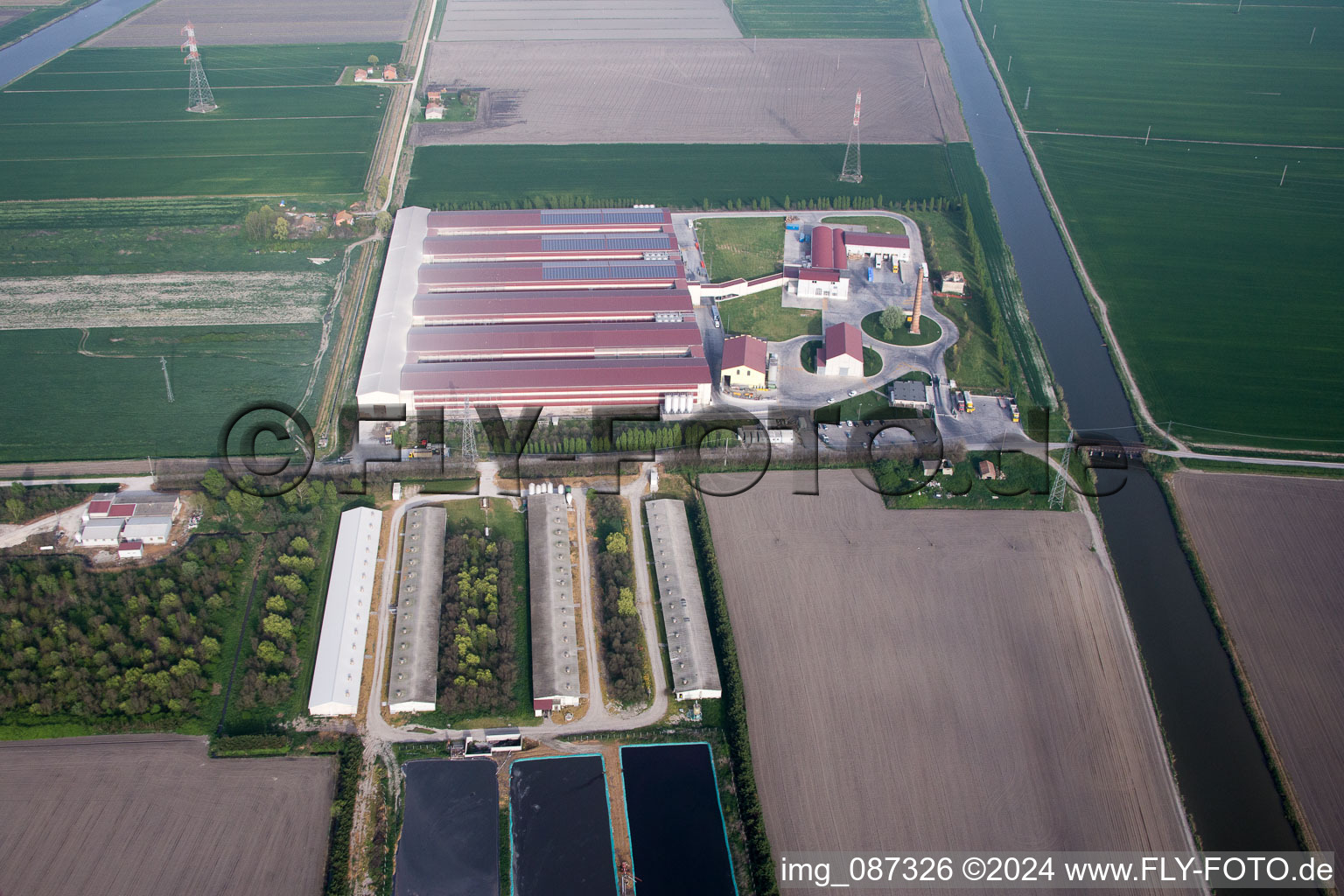 Luftaufnahme von Tierzucht- Stallanlagen Schweinezucht für die Schweinefleischproduktion kombiniert mit Fischzuchtbecken in Codigoro in Emilia-Romagna, Italien