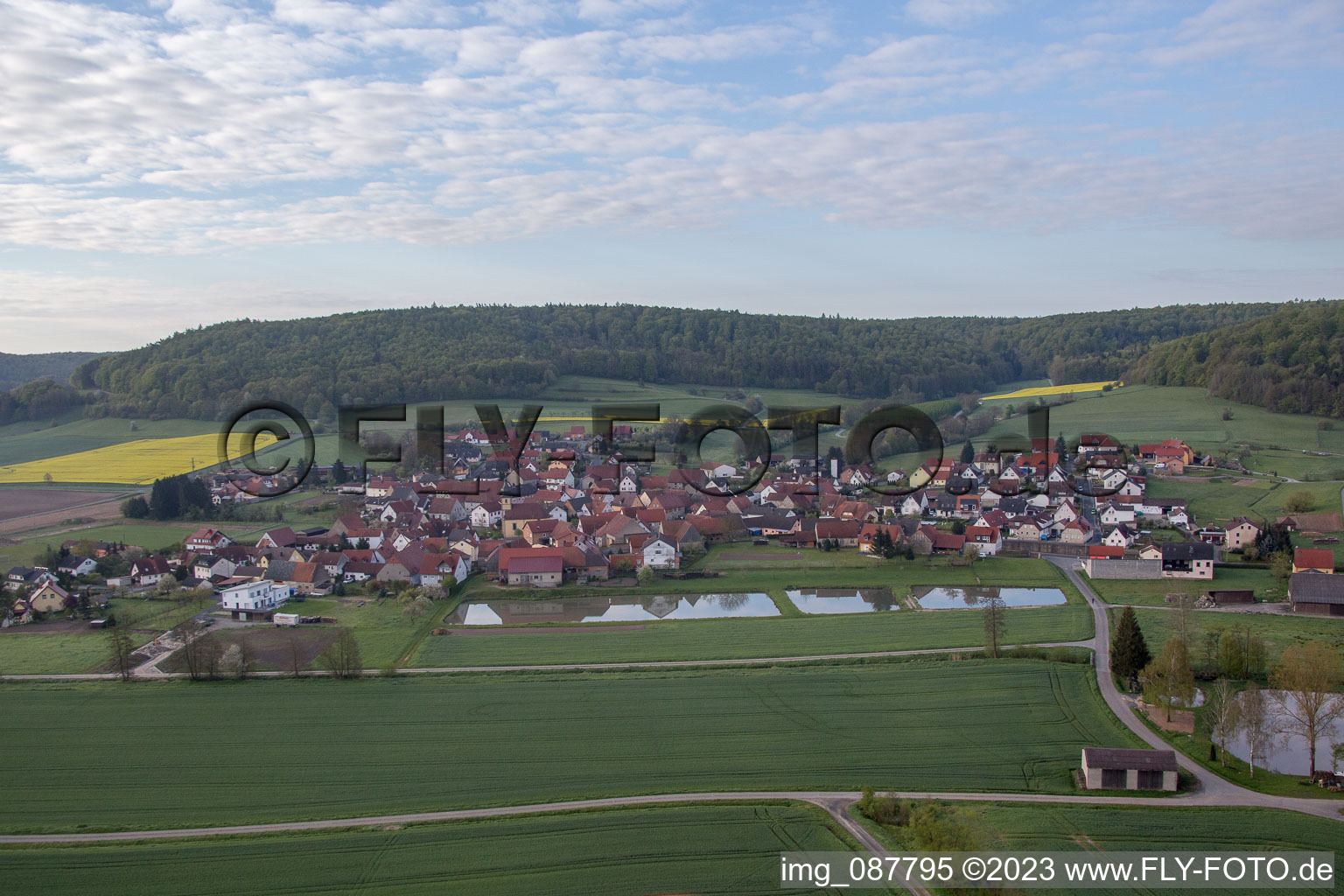 Luftaufnahme von Dorf - Ansicht am Rande von landwirtschaftlichen Feldern und Nutzflächen in Geusfeld bei Rauhenebrach im Bundesland Bayern, Deutschland