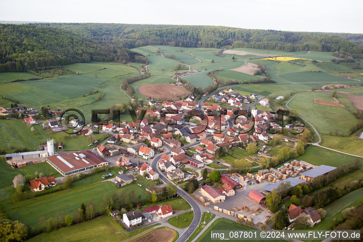 Dorf - Ansicht am Rande von landwirtschaftlichen Feldern und Nutzflächen im Ortsteil Wustviel in Rauhenebrach im Bundesland Bayern, Deutschland