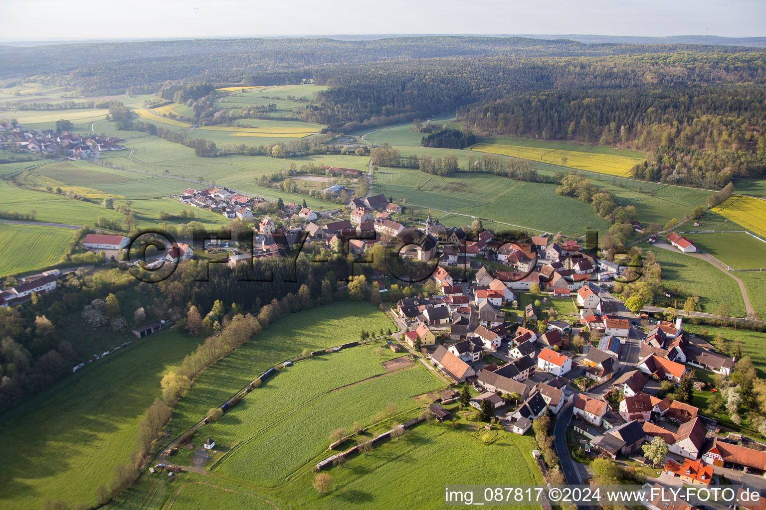 Dorf - Ansicht am Rande von landwirtschaftlichen Feldern und Nutzflächen in Prölsdorf im Bundesland Bayern, Deutschland