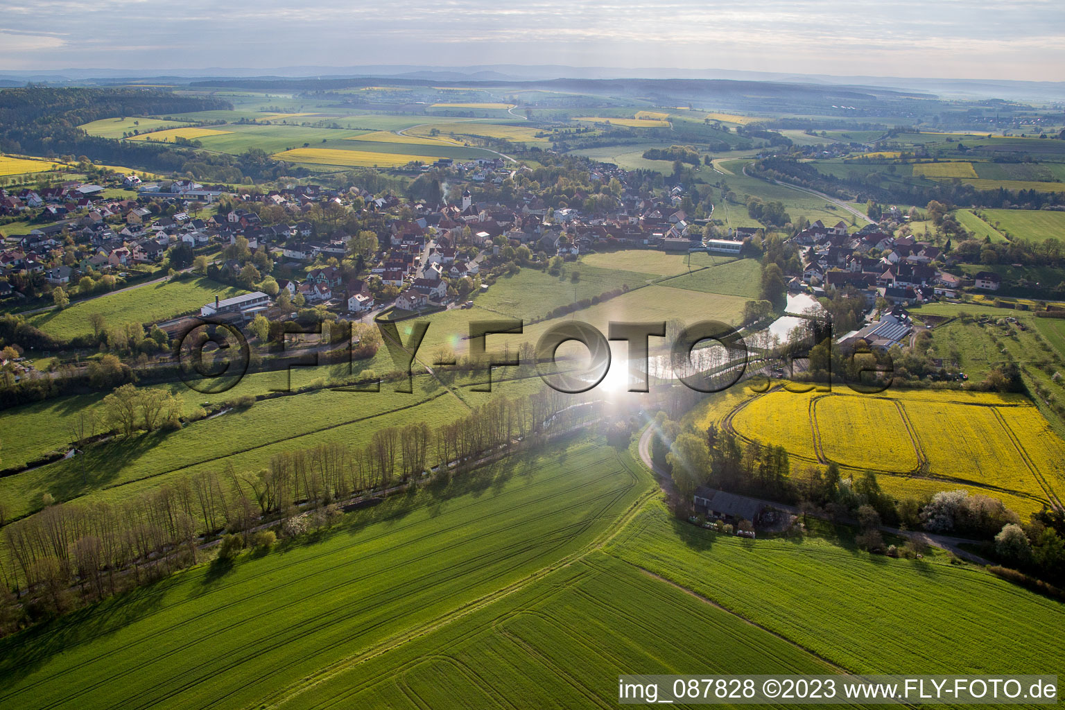 Dorf - Ansicht am Rande von landwirtschaftlichen Feldern und Nutzflächen in Schönbrunn im Steigerwald im Bundesland Bayern, Deutschland