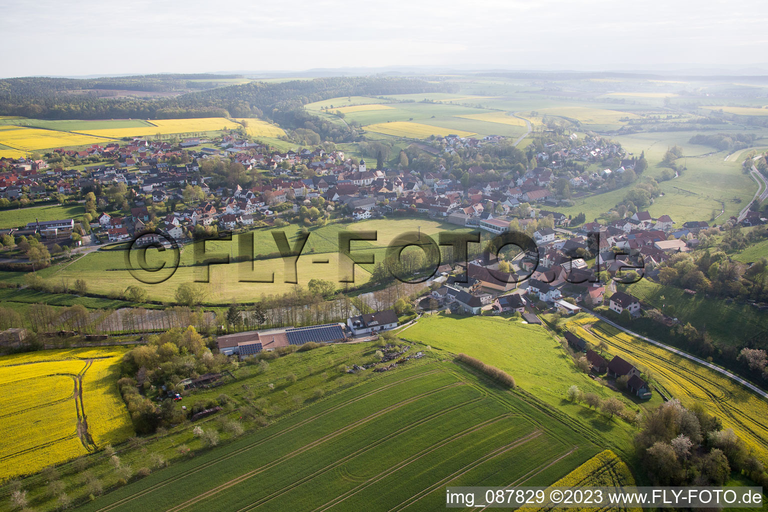 Luftbild von Dorf - Ansicht am Rande von landwirtschaftlichen Feldern und Nutzflächen in Schönbrunn im Steigerwald im Bundesland Bayern, Deutschland
