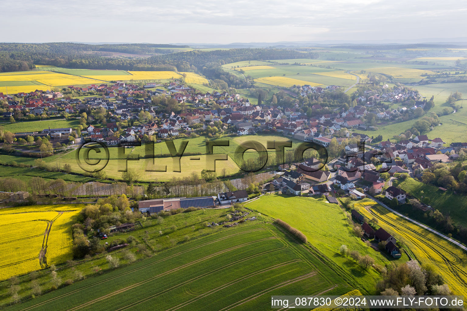 Luftaufnahme von Dorf - Ansicht am Rande von landwirtschaftlichen Feldern und Nutzflächen in Schönbrunn im Steigerwald im Bundesland Bayern, Deutschland