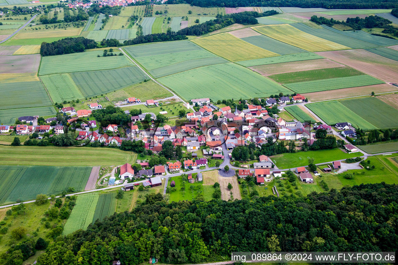 Dorf - Ansicht am Rande von landwirtschaftlichen Feldern und Nutzflächen in Theinfeld im Bundesland Bayern, Deutschland