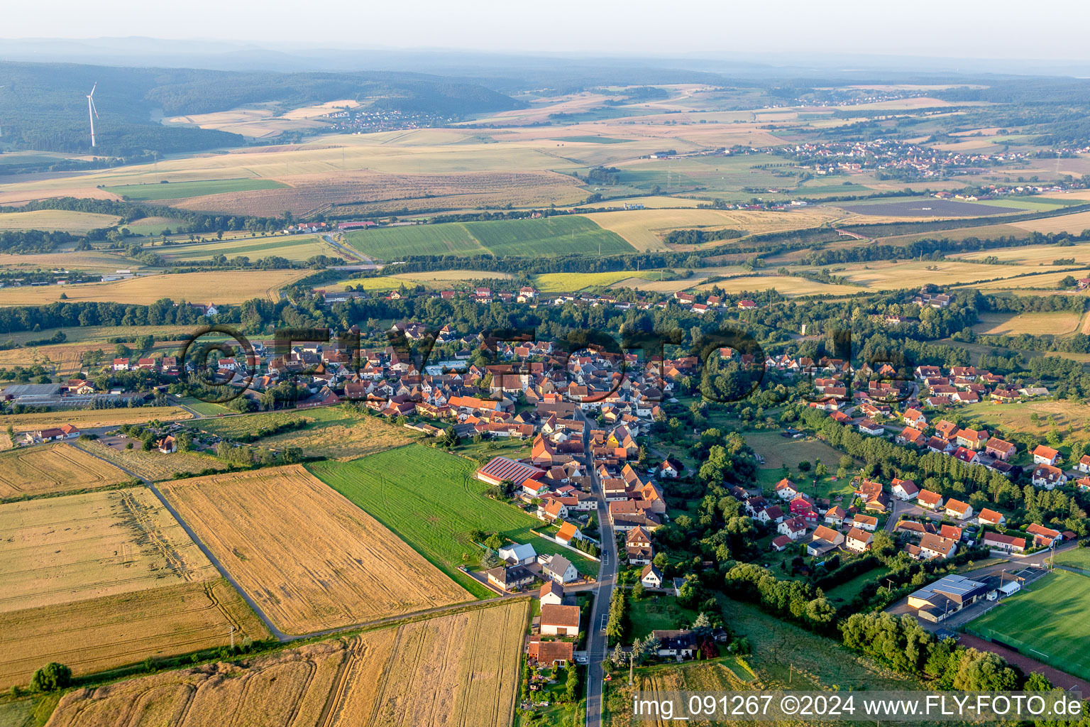 Dorf - Ansicht am Rande von landwirtschaftlichen Feldern und Nutzflächen in Steinbach am Donnersberg im Bundesland Rheinland-Pfalz, Deutschland