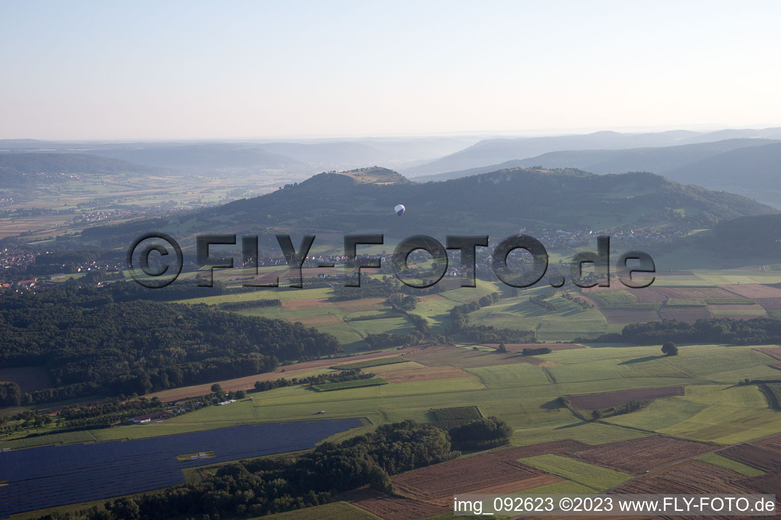 Heißluftballon im Morgendunst der Fränkischen Schweiz in Fahrt über dem Luftraum in Pinzberg im Bundesland Bayern, Deutschland