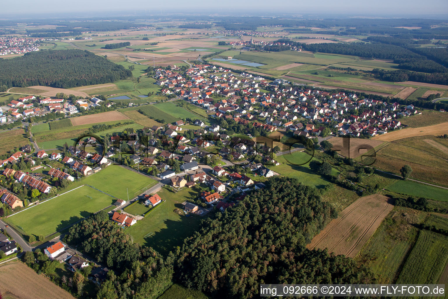 Dorf - Ansicht am Rande von landwirtschaftlichen Feldern und Nutzflächen in Heßdorf im Bundesland Bayern, Deutschland