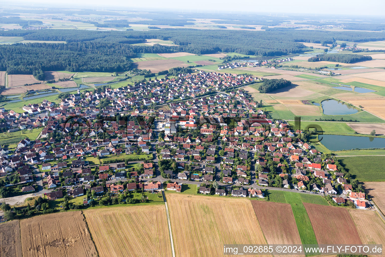 Dorf - Ansicht am Rande von landwirtschaftlichen Feldern und Karpfenteichen in Weisendorf im Bundesland Bayern, Deutschland