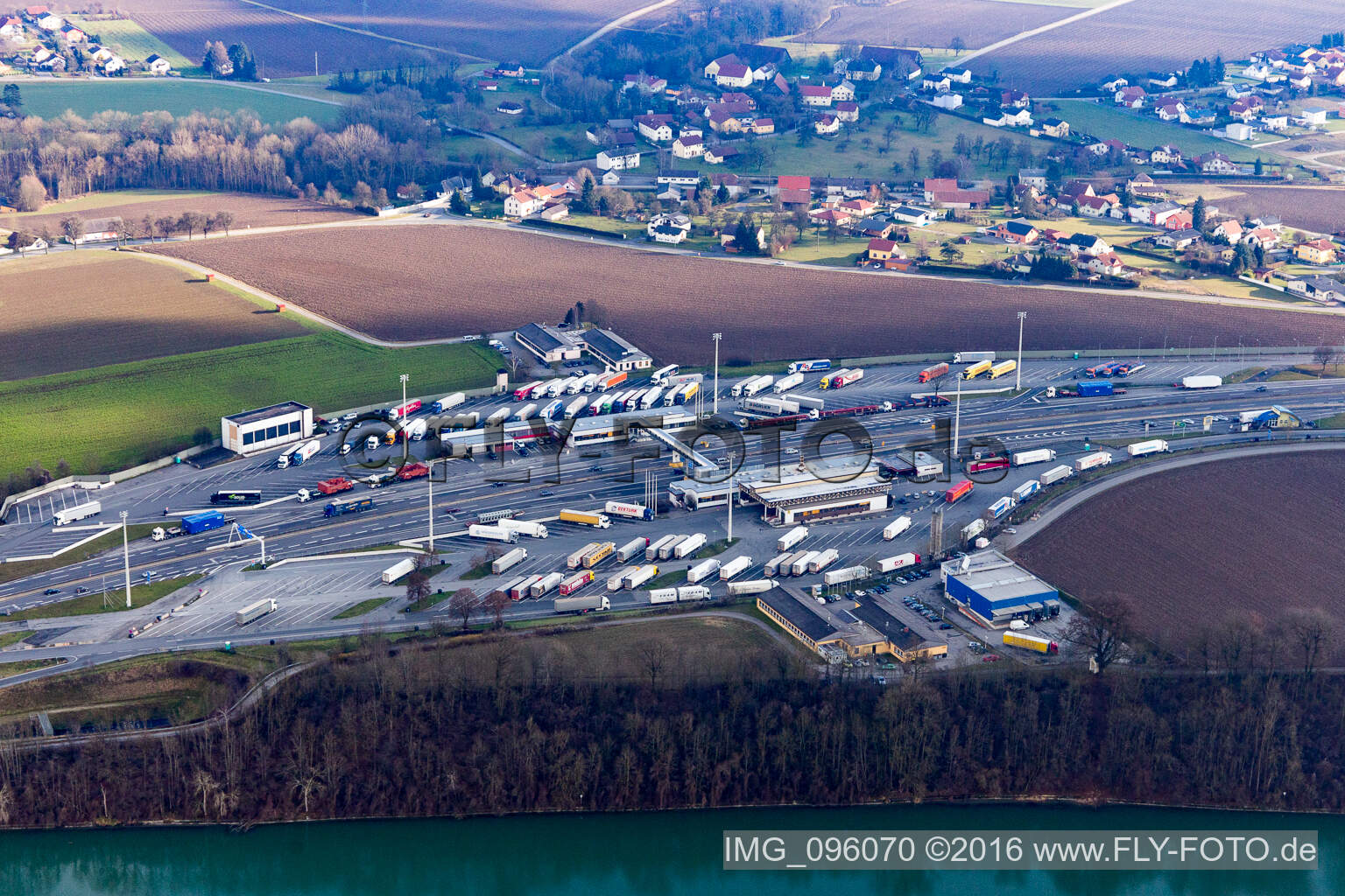 Luftbild von Autobahn-Grenzübergang LKW-Grenzkontrollen an der A8 von Österreich zur A3 in Deutschland am Inn in Suben in Oberösterreich