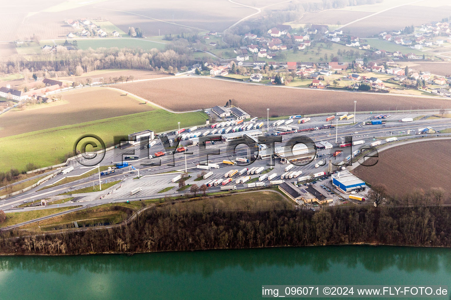 Luftaufnahme von Autobahn-Grenzübergang LKW-Grenzkontrollen an der A8 von Österreich zur A3 in Deutschland am Inn in Suben in Oberösterreich