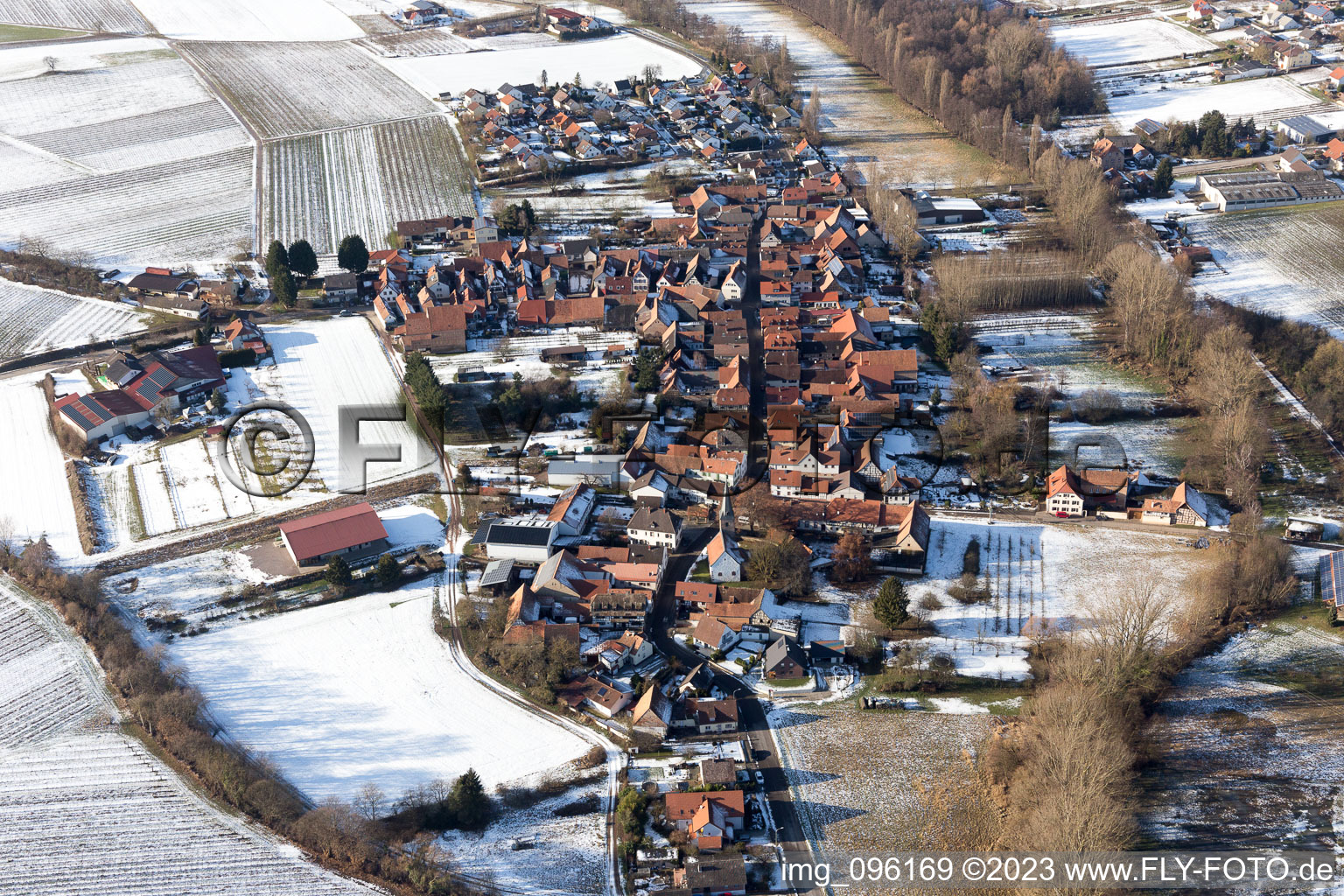 Winterlich schneebedeckte Dorf - Ansicht am Rande von landwirtschaftlichen Feldern und Nutzflächen im Ortsteil Heuchelheim in Heuchelheim-Klingen im Bundesland Rheinland-Pfalz, Deutschland