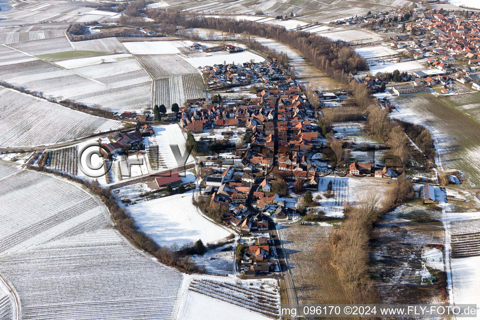 Winterlich schneebedeckte Dorf - Ansicht am Rande von landwirtschaftlichen Feldern und Nutzflächen im Ortsteil Klingen in Heuchelheim-Klingen im Bundesland Rheinland-Pfalz, Deutschland
