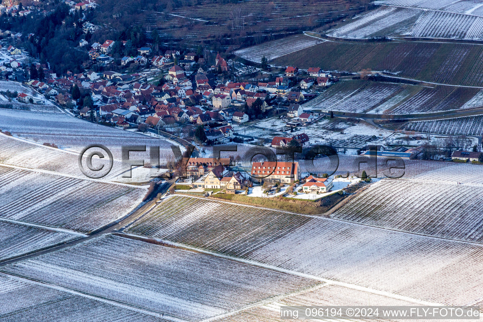 Winterlich schneebedeckte Gebäudekomplex der Hotelanlage Leinsweiler Hof in Leinsweiler im Bundesland Rheinland-Pfalz, Deutschland