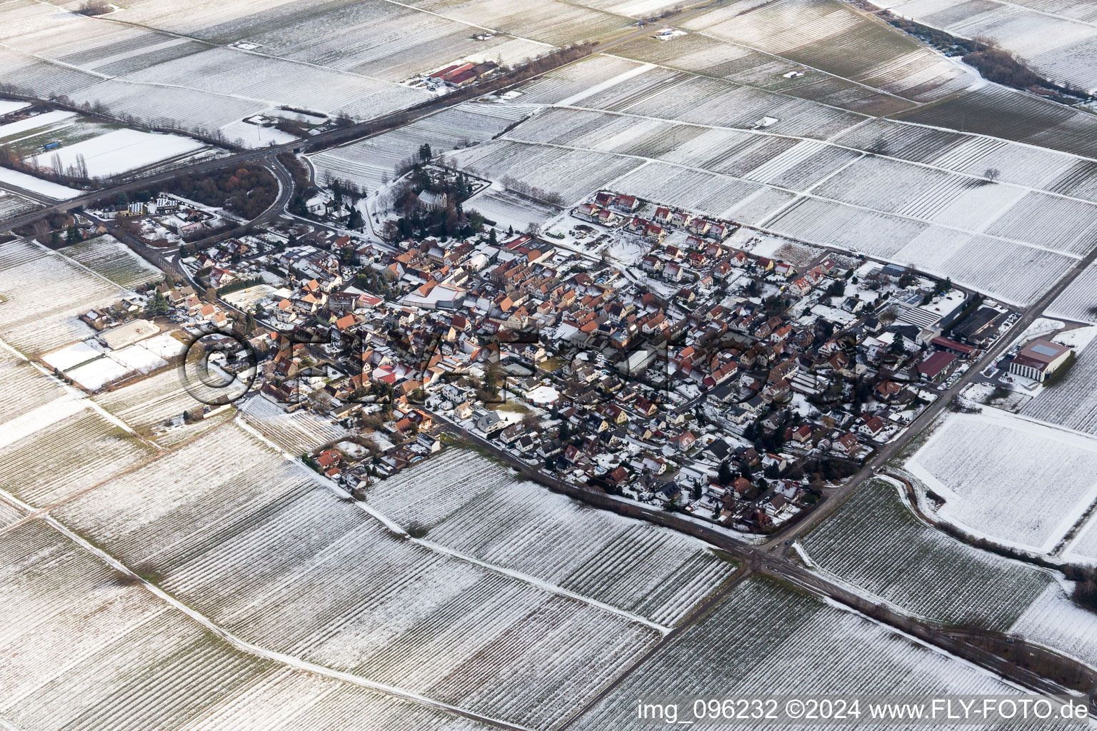 Winterlich schneebedeckte Dorf - Ansicht am Rande von landwirtschaftlichen Feldern und Nutzflächen in Walsheim im Bundesland Rheinland-Pfalz, Deutschland