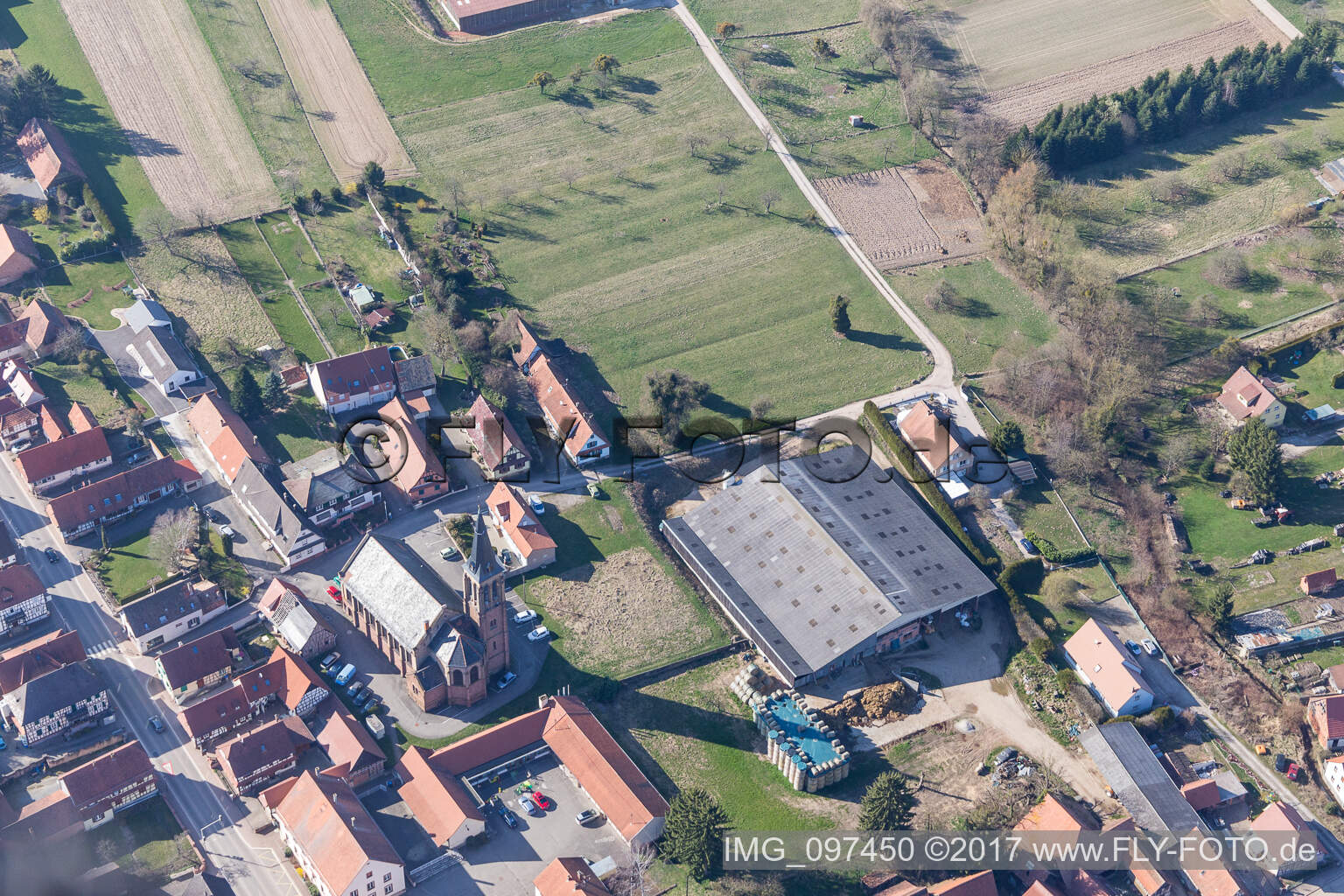 Luftaufnahme von Kirchengebäude im Dorfkern in Betschdorf in Grand Est im Bundesland Bas-Rhin, Frankreich