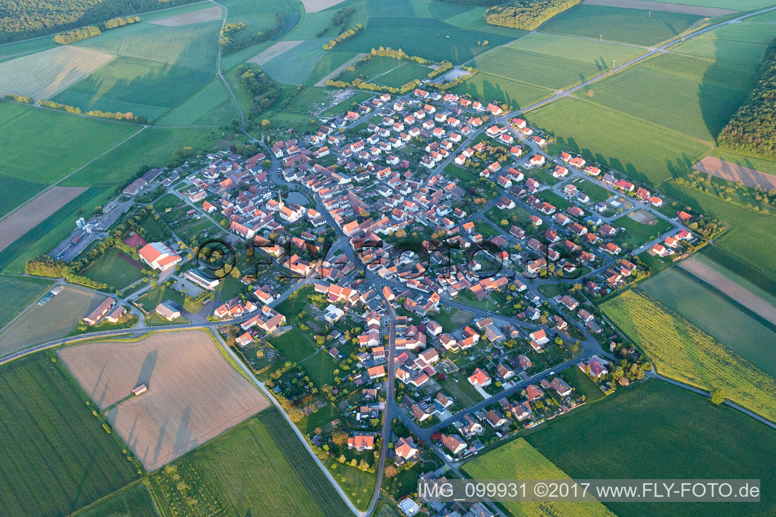 Schrägluftbild von Dorf - Ansicht am Rande von landwirtschaftlichen Feldern und Nutzflächen in Wasserlosen im Bundesland Bayern, Deutschland
