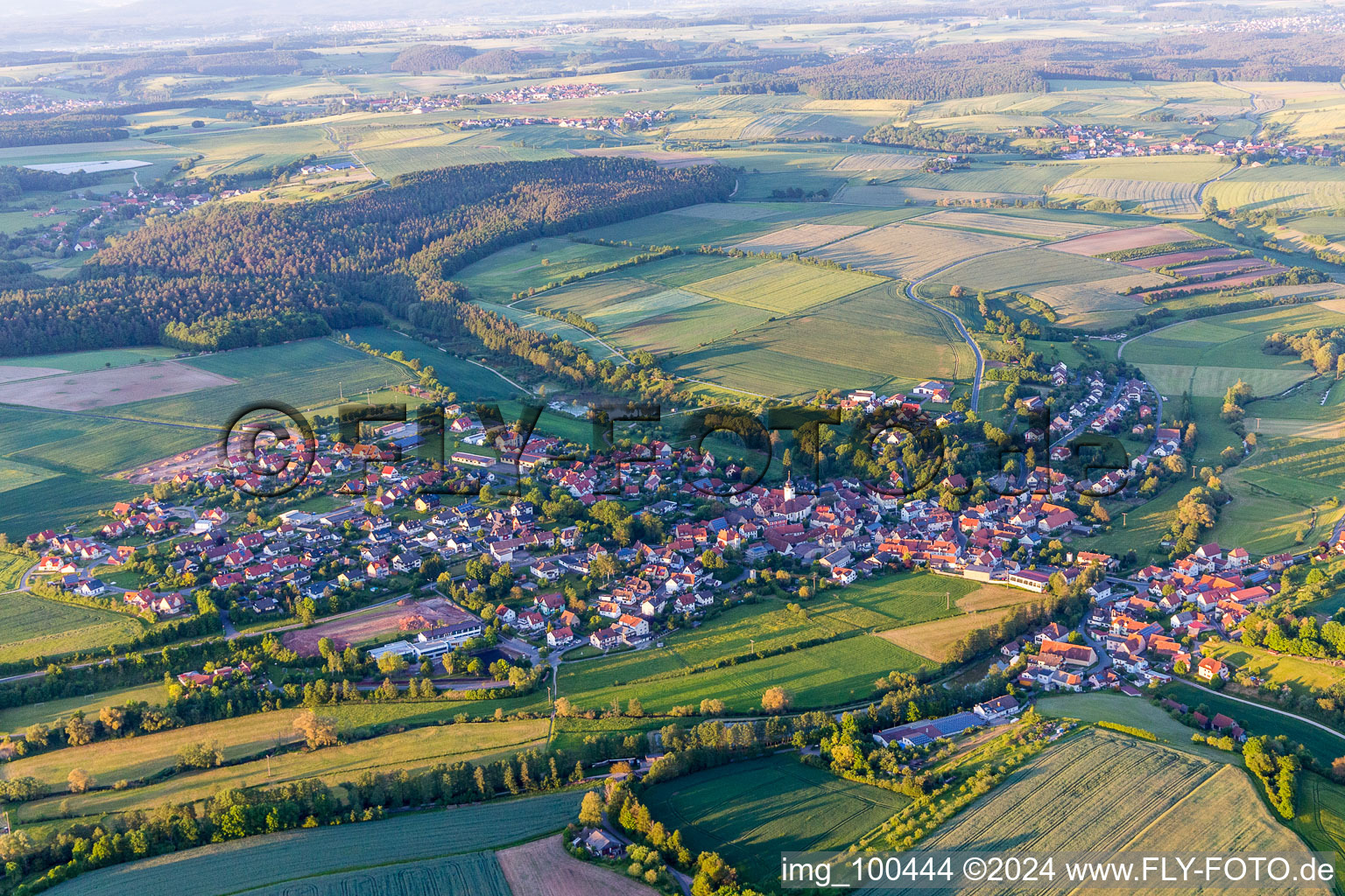 Schrägluftbild von Dorf - Ansicht am Rande von landwirtschaftlichen Feldern und Nutzflächen in Schönbrunn im Steigerwald im Bundesland Bayern, Deutschland