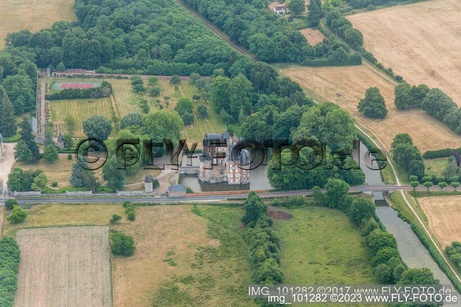 Schrägluftbild von Gebäude und Schloßpark- Anlagen des Wasserschloß Château de Combreux in Combreux in Centre-Val de Loire im Bundesland Loiret, Frankreich