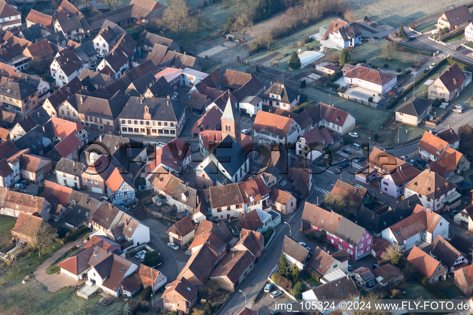 Luftaufnahme von Gebäude der von einem Häuserring umgebenen lutherisch-protestantischen Wehrkirche im Dorfkern in Dossenheim-sur-Zinsel in Grand Est im Bundesland Bas-Rhin, Frankreich