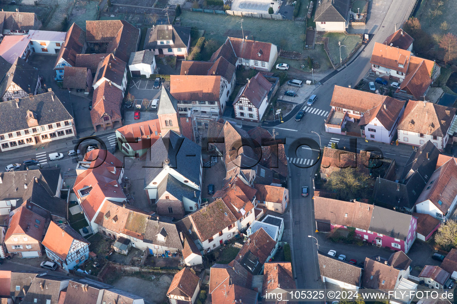 Schrägluftbild von Gebäude der von einem Häuserring umgebenen lutherisch-protestantischen Wehrkirche im Dorfkern in Dossenheim-sur-Zinsel in Grand Est im Bundesland Bas-Rhin, Frankreich
