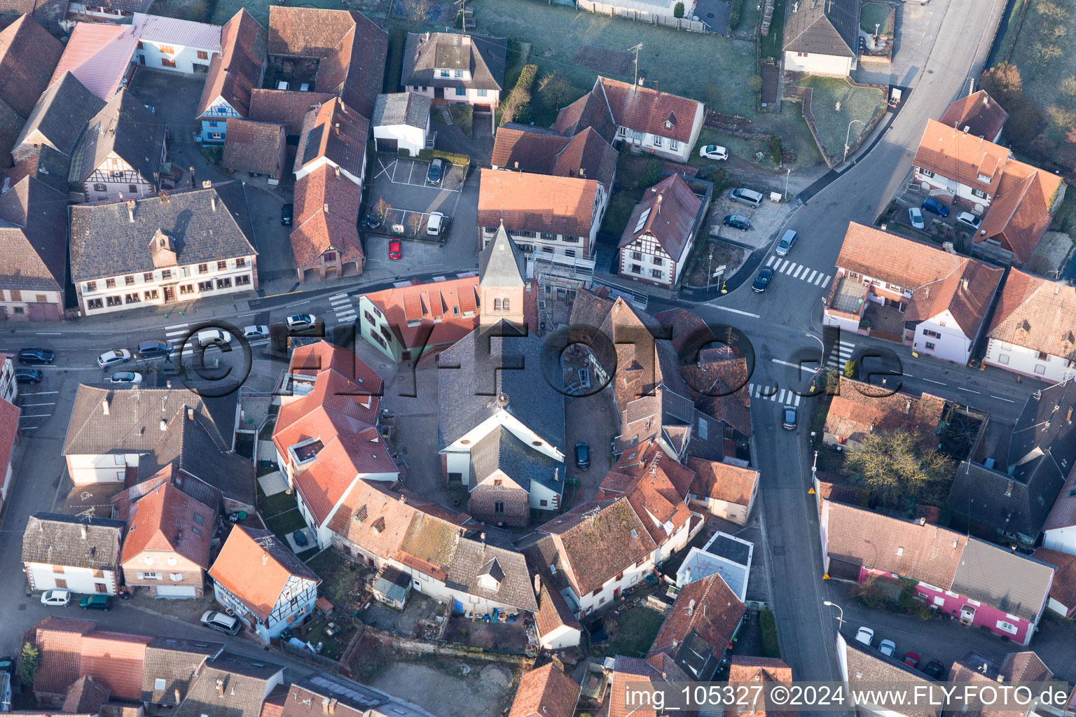 Gebäude der von einem Häuserring umgebenen lutherisch-protestantischen Wehrkirche im Dorfkern in Dossenheim-sur-Zinsel in Grand Est im Bundesland Bas-Rhin, Frankreich aus der Luft