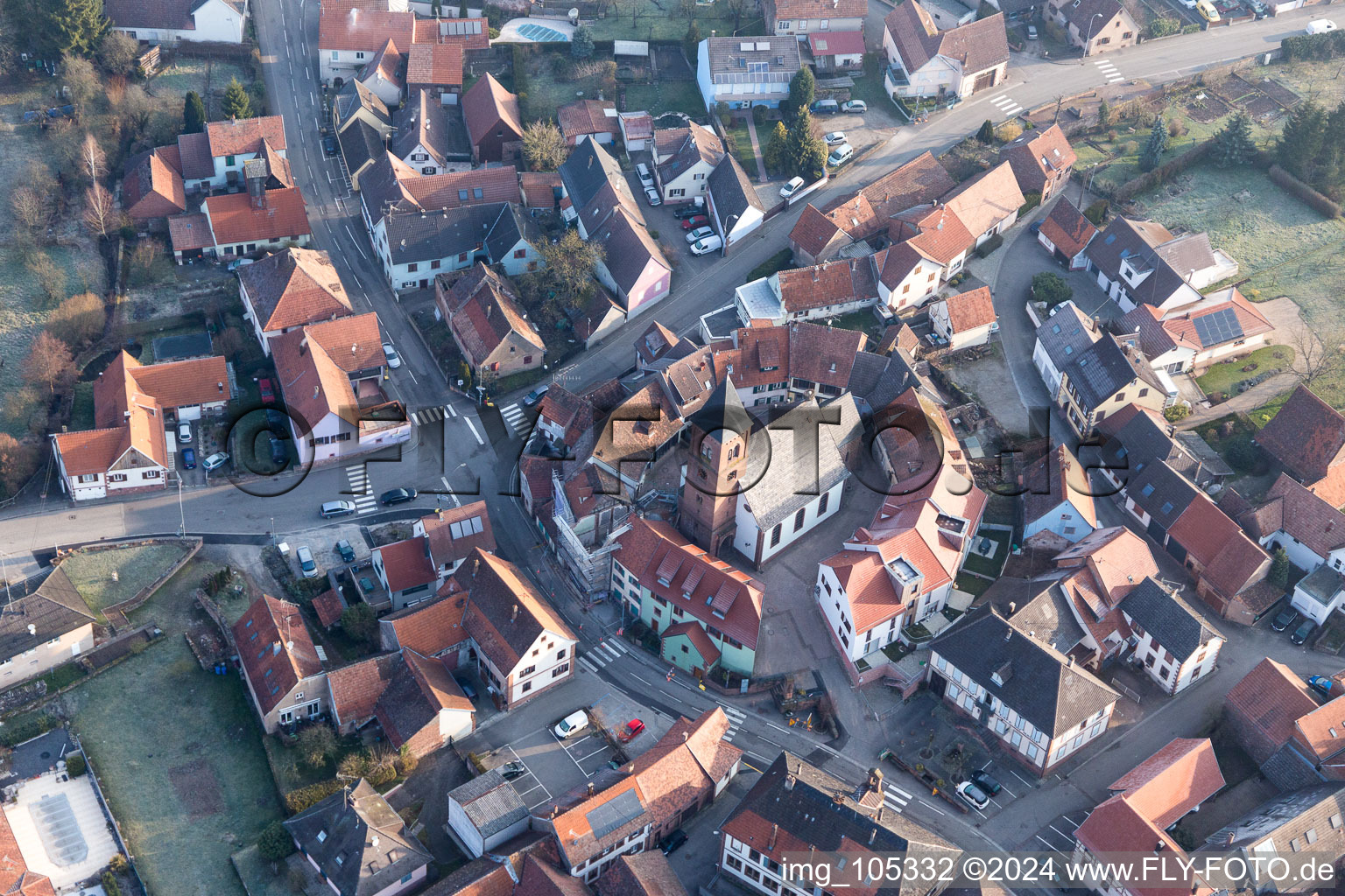 Drohnenaufname von Gebäude der von einem Häuserring umgebenen lutherisch-protestantischen Wehrkirche im Dorfkern in Dossenheim-sur-Zinsel in Grand Est im Bundesland Bas-Rhin, Frankreich