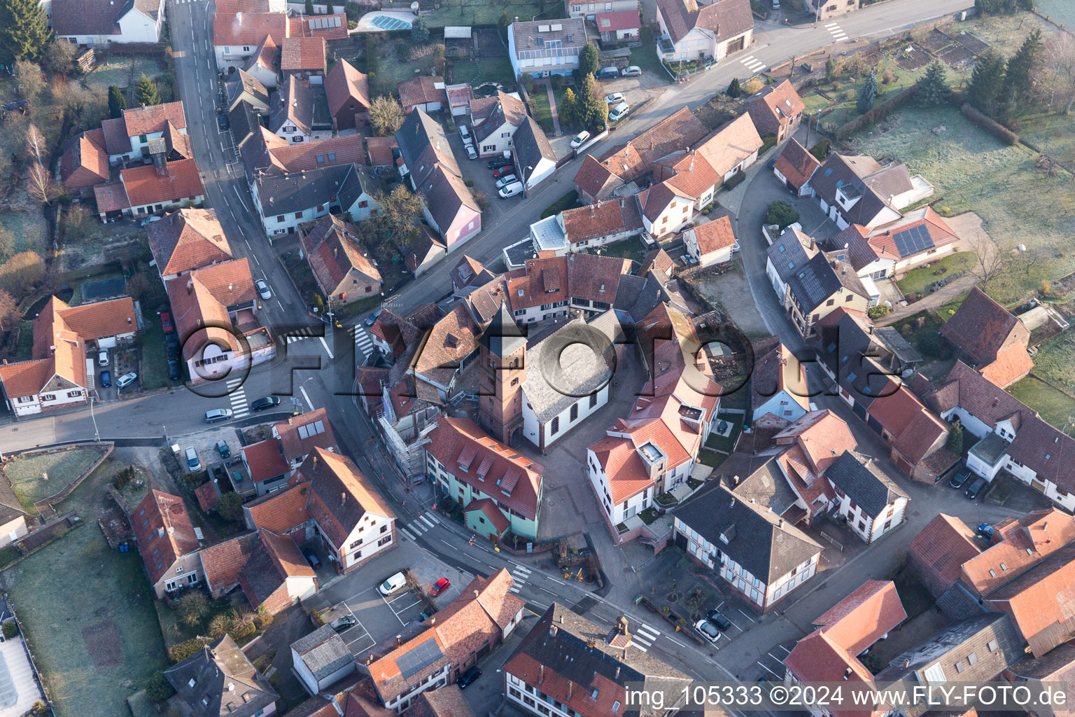 Drohnenbild von Gebäude der von einem Häuserring umgebenen lutherisch-protestantischen Wehrkirche im Dorfkern in Dossenheim-sur-Zinsel in Grand Est im Bundesland Bas-Rhin, Frankreich