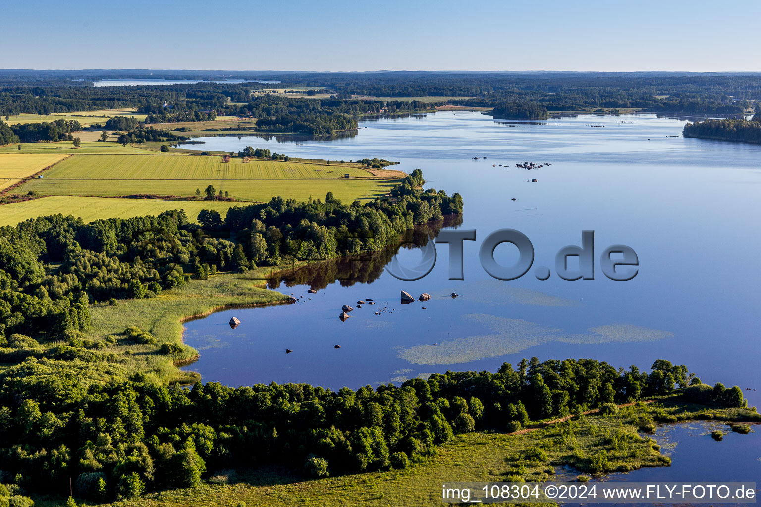 Waldgebiete an Uferbucht im moorfarbenen Åsnen-See bei Hunna in Småland in Kronobergs län, Schweden