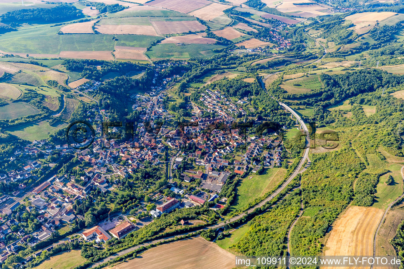 Ortsansicht der Straßen und Häuser der Wohngebiete in der von Bergen umgebenen Tallandschaft in Alsenz im Bundesland Rheinland-Pfalz, Deutschland