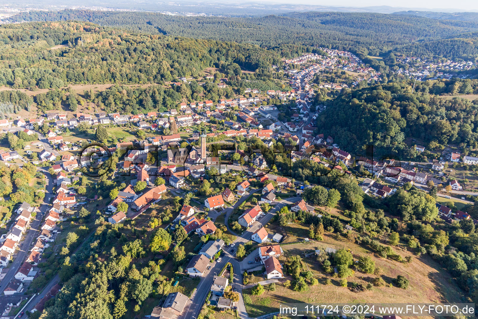 Ortsansicht der Straßen und Häuser der Wohngebiete in der von Bergen umgebenen Tallandschaft in Kirrberg im Bundesland Saarland, Deutschland