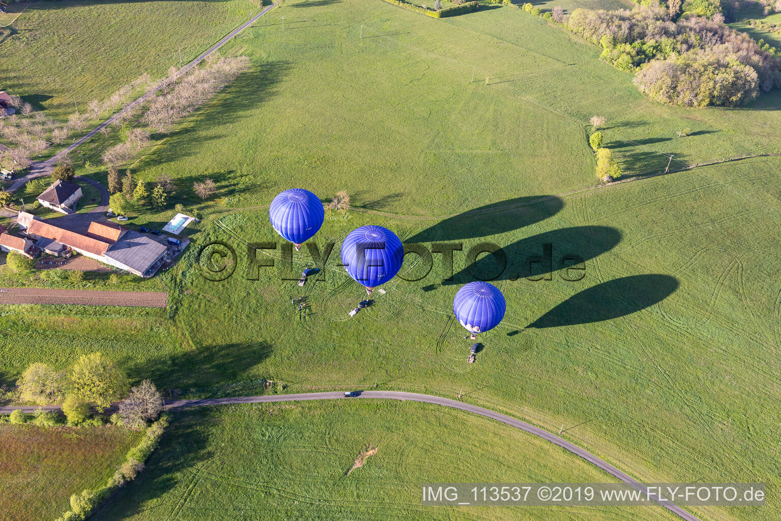 Luftbild von Drei blaue Heißluftballone beim Start in der Dordogne in Veyrines-de-Domme in Nouvelle-Aquitaine, Frankreich