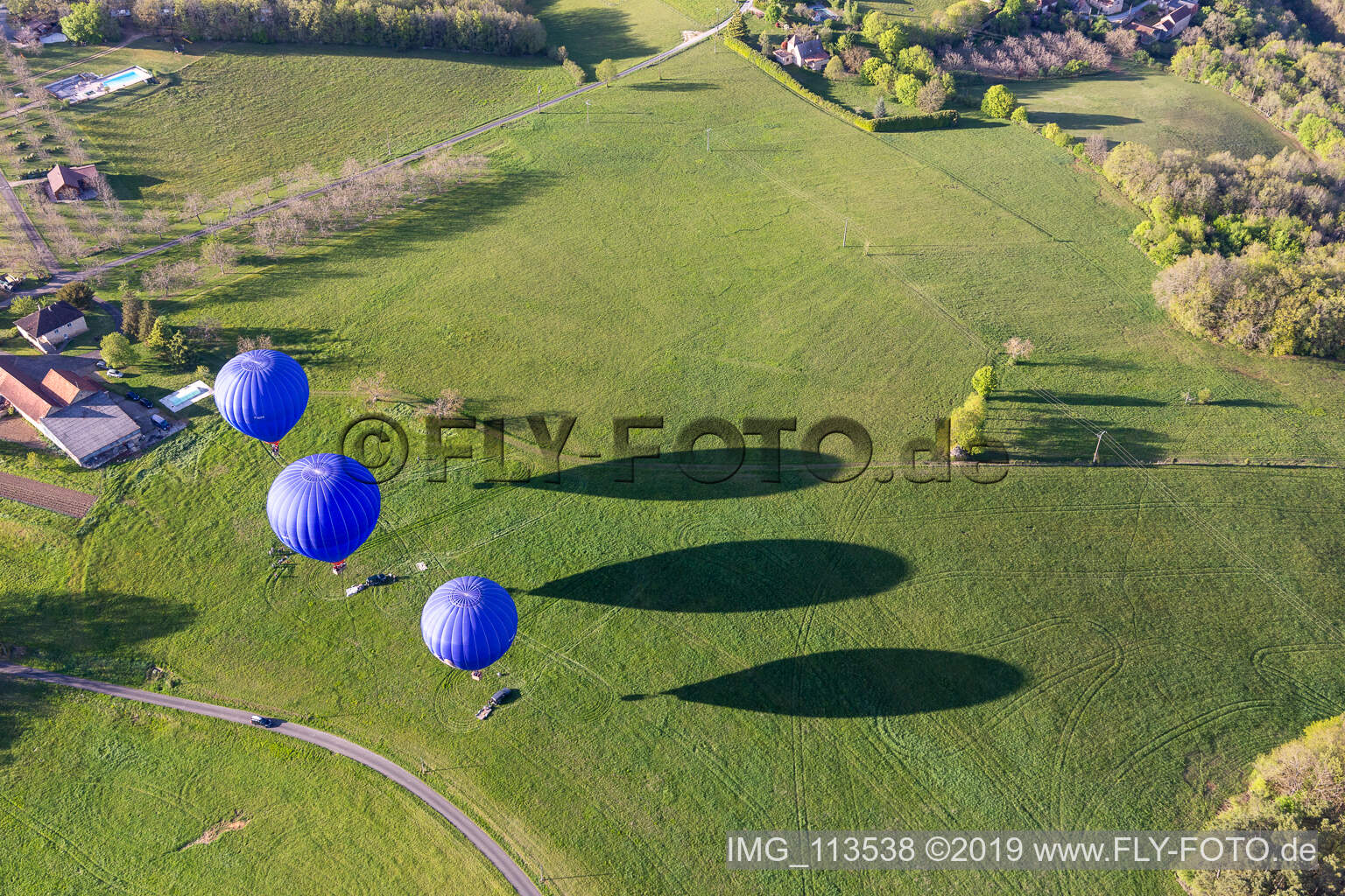 Luftaufnahme von Drei blaue Heißluftballone beim Start in der Dordogne in Veyrines-de-Domme in Nouvelle-Aquitaine, Frankreich