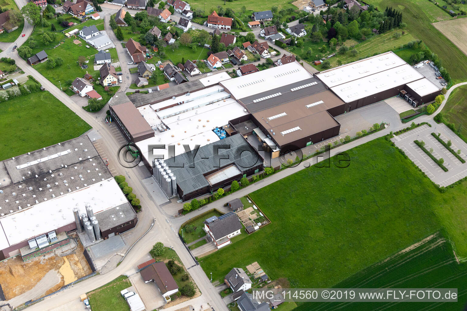 Luftbild von Gebäude und Produktionshallen auf dem Werksgelände der Saier Verpackungstechnik in Alpirsbach im Bundesland Baden-Württemberg, Deutschland