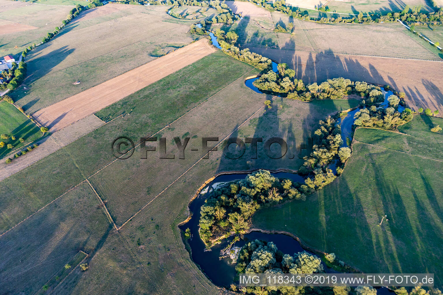 Kurvenförmige Mäander der mit Weiden bewachsenen Ufer der Maas/Meuse zwischen Feldern in Maxey-sur-Meuse in Grand Est im Bundesland Vosges, Frankreich