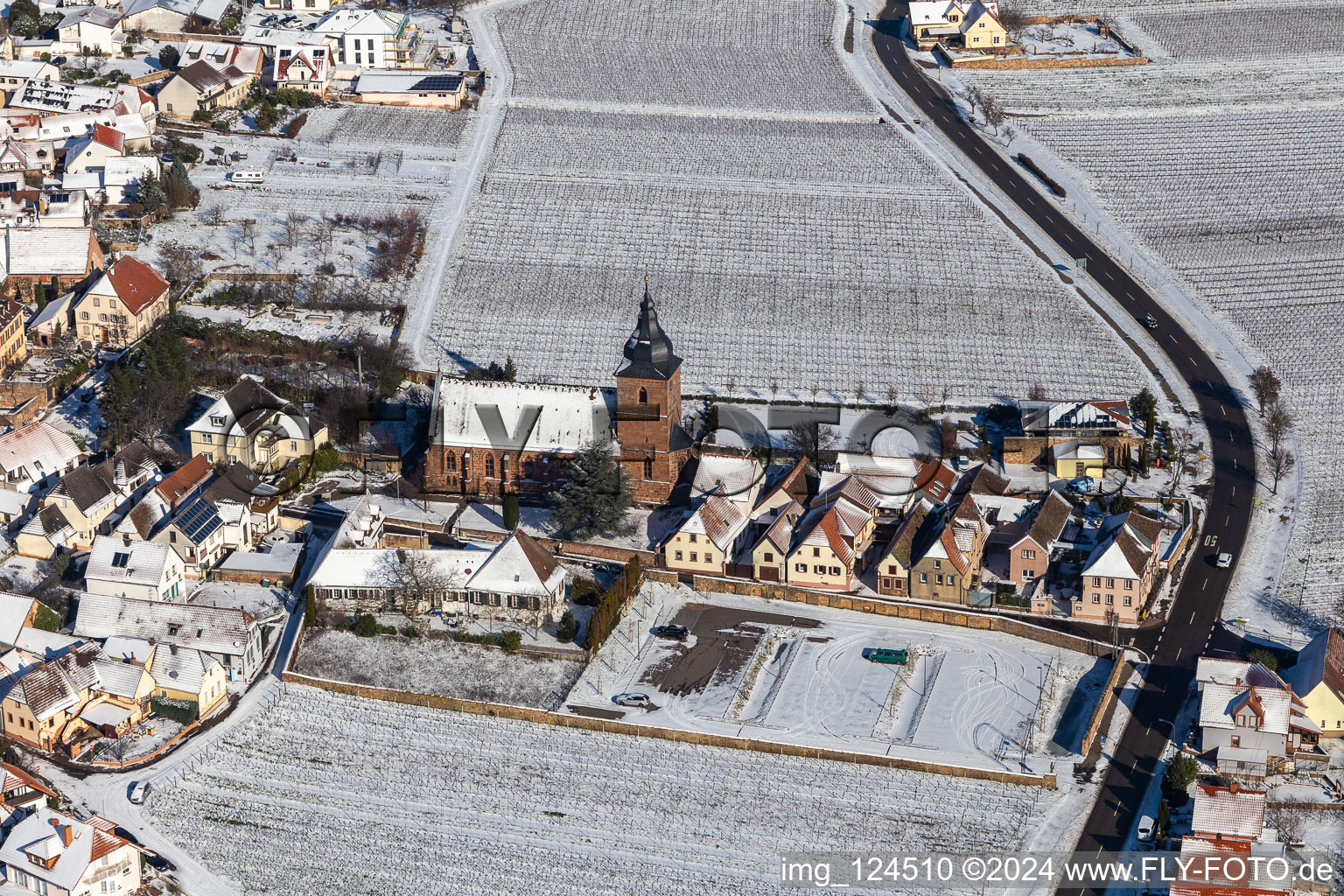 Winterlich schneebedeckte Kirchengebäude der Katholischen Pfarrkirche Maria Heimsuchung, Das Weinhaus Vinothek Meßmer, Ritterhof zur Rose in Burrweiler im Bundesland Rheinland-Pfalz, Deutschland