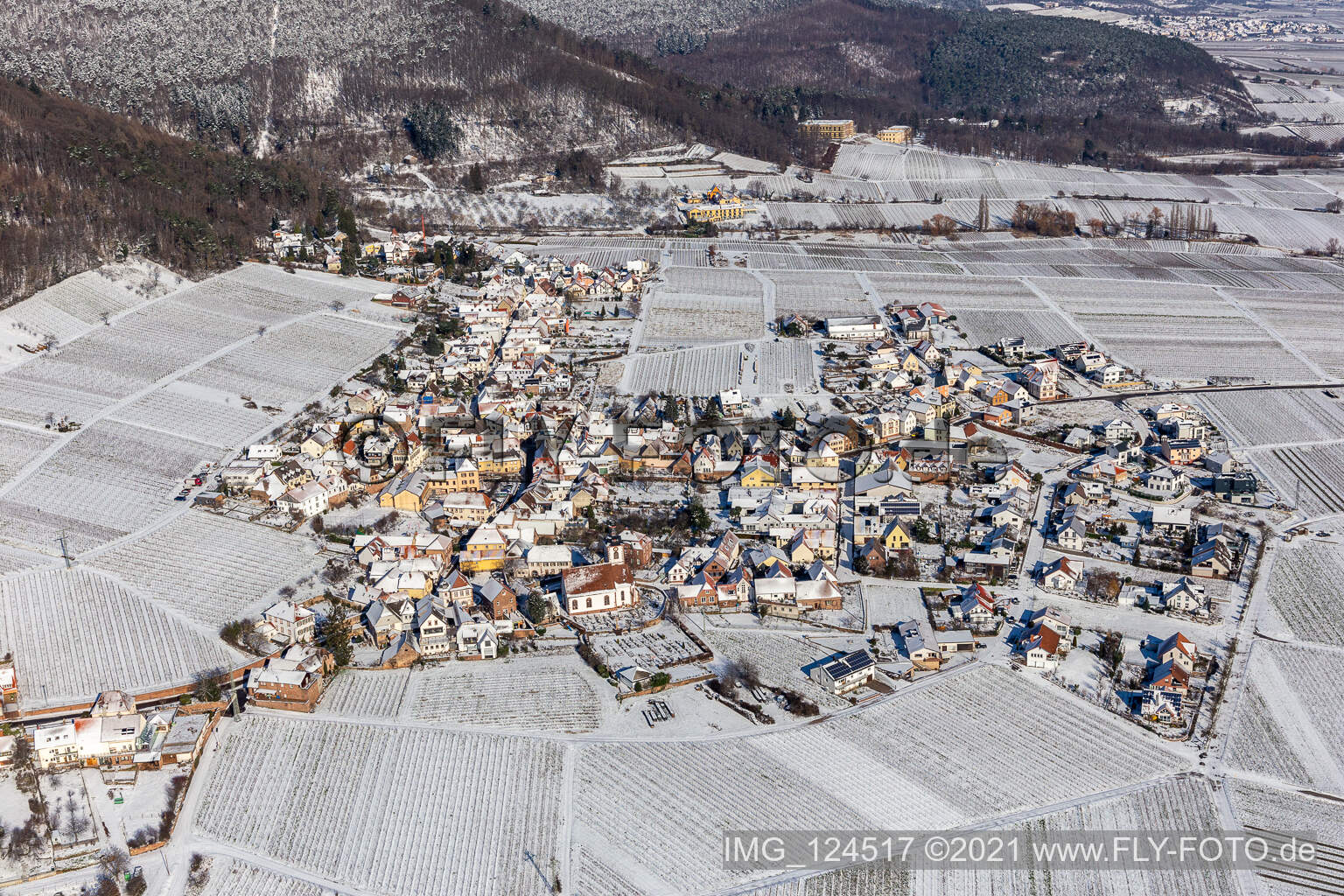 Winterlich schneebedeckte Dorfkern am Rande von Weinbergen und Winzer- Gütern im Weinbaugebiet in Weyher in der Pfalz im Bundesland Rheinland-Pfalz, Deutschland