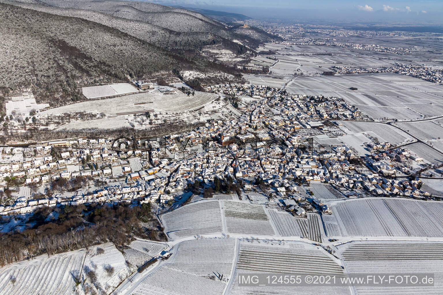 Winterlich schneebedeckte Dorf - Ansicht am Rande der Haardt des Pfälzerwalds zwischen Weinbergen in Sankt Martin im Bundesland Rheinland-Pfalz, Deutschland