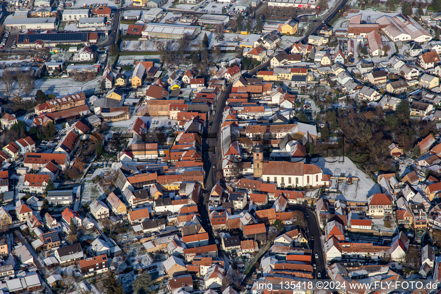 Luftaufnahme von Hauptstraße mit Pfarrkirche St. Michael im Winter bei Schnee in Rheinzabern im Bundesland Rheinland-Pfalz, Deutschland