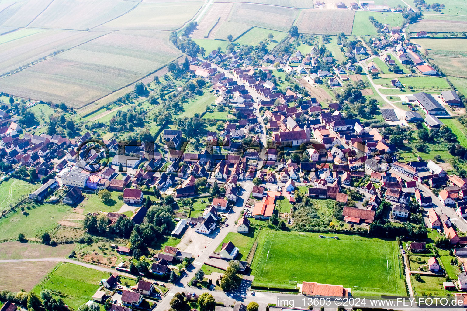 Schrägluftbild von Dorf - Ansicht am Rande von landwirtschaftlichen Feldern und Nutzflächen in Riedseltz in Grand Est im Bundesland Bas-Rhin, Frankreich