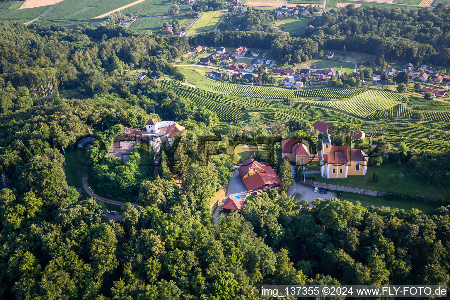 Kirche Župnijska cerkev sv. Marije Vnebovzete und Café Huda Liza auf dem Vurberg im Ortsteil Vurberk in Duplek, Slowenien vom Flugzeug aus