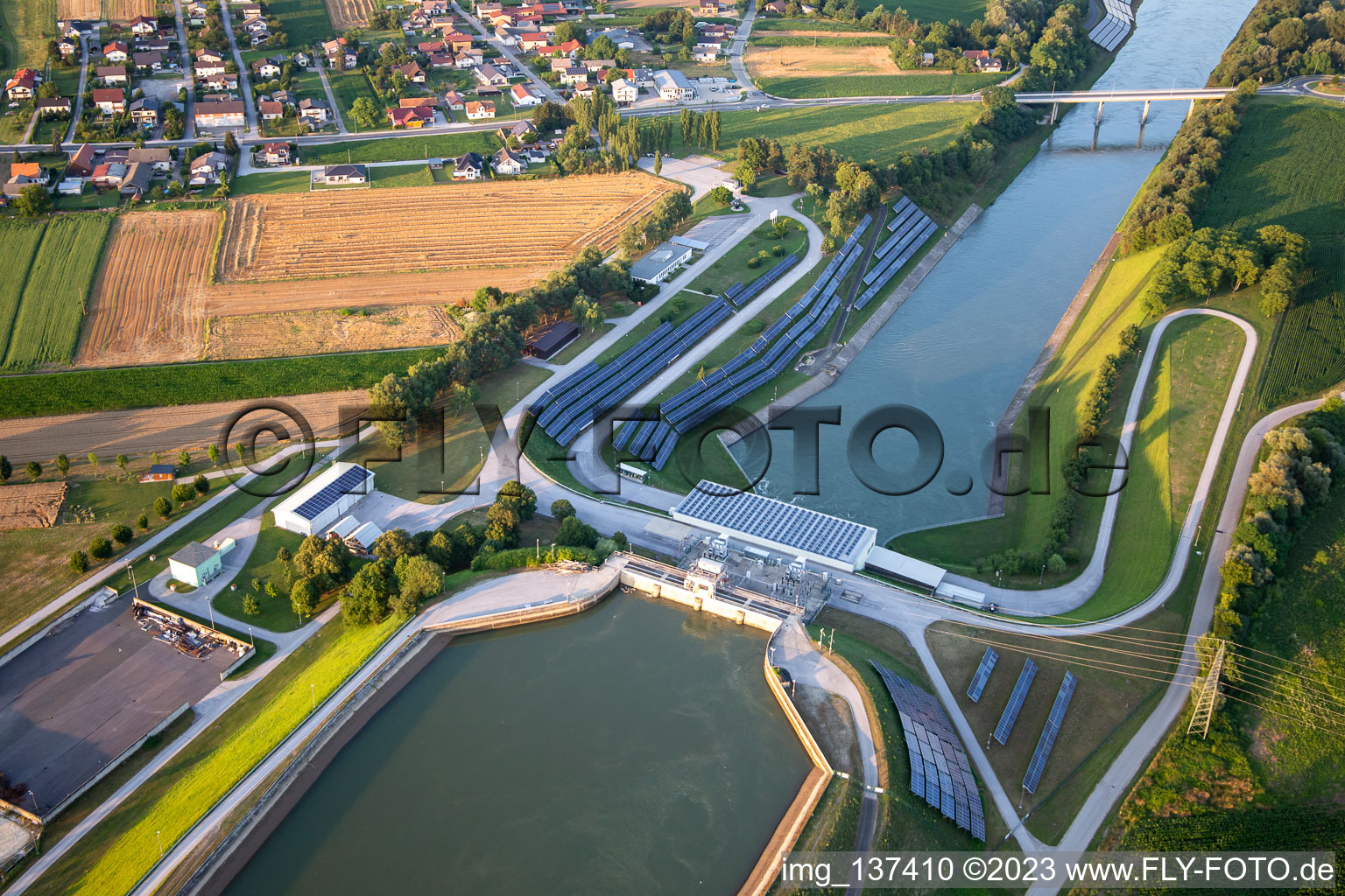 Luftaufnahme von Wasserkraftwerk HE Zlatoličje mit Photovoltaik-Panels an der Uferböschung am Drau-Kanal HE Zlatoličje in Starše, Slowenien