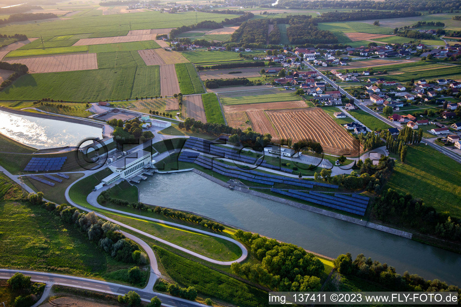 Schrägluftbild von Wasserkraftwerk HE Zlatoličje mit Photovoltaik-Panels an der Uferböschung am Drau-Kanal HE Zlatoličje in Starše, Slowenien