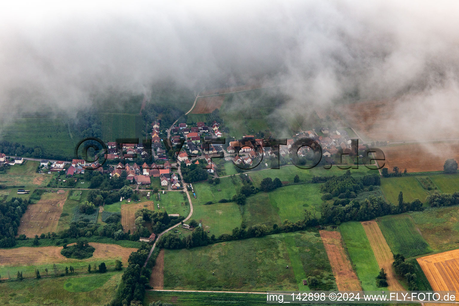 Ortschaft von Norden unter tiefen Wolken in Hergersweiler im Bundesland Rheinland-Pfalz, Deutschland