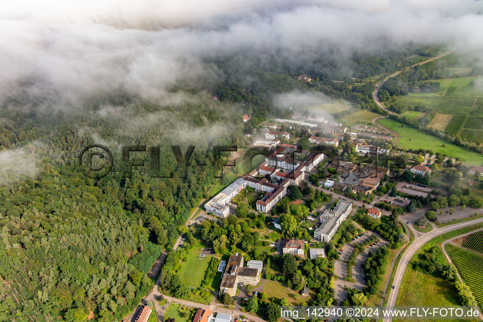 Dichte Wolken über dem Pfalzklinikum für Psychiatrie und Neurologie in Klingenmünster im Bundesland Rheinland-Pfalz, Deutschland vom Flugzeug aus