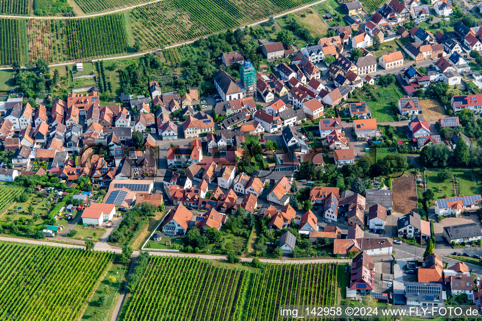 Ortschaft von Süden mit eingerüsteter  Katholische Pfarr- und Wallfahrtskirche Allerheiligen in Ranschbach im Bundesland Rheinland-Pfalz, Deutschland