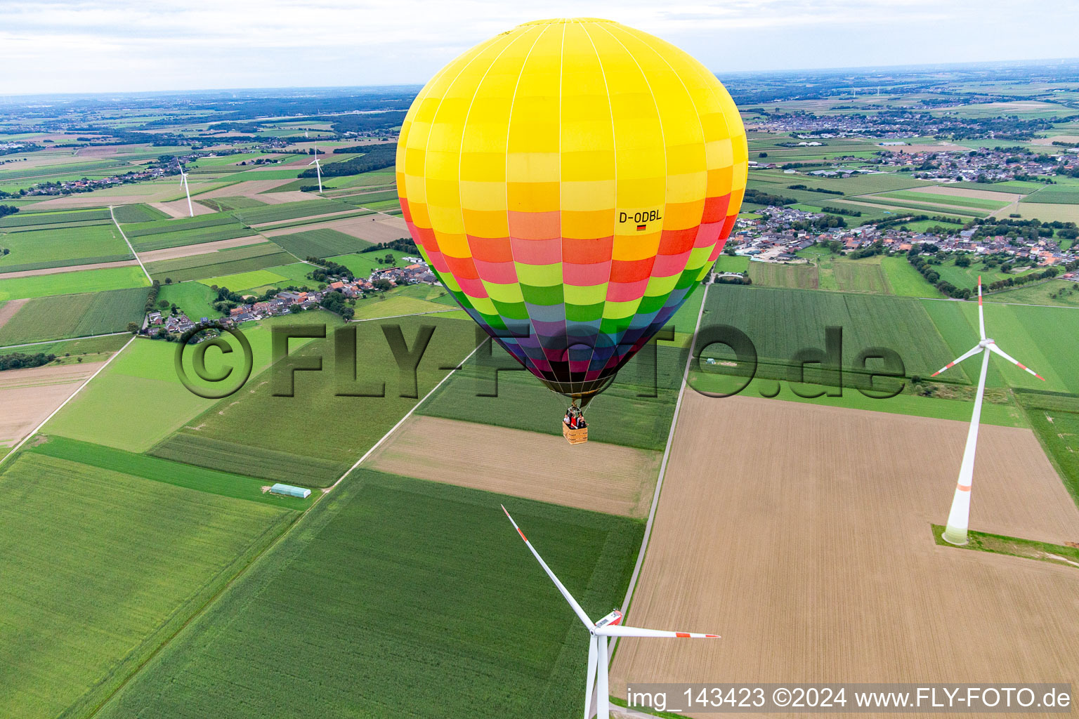 Schrägluftbild von Heißluftballon fährt knapp am Windrad im Ortsteil Uetterath in Heinsberg im Bundesland Nordrhein-Westfalen, Deutschland